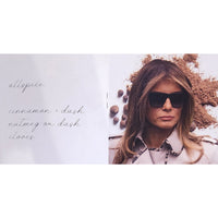 Woman wearing sunglasses with spices and herbs around her on a white background